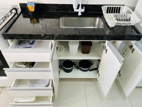 a kitchen counter with white cabinets and a sink at Venha Curtir as Melhores Praias de Cabo Frio 306 in Cabo Frio