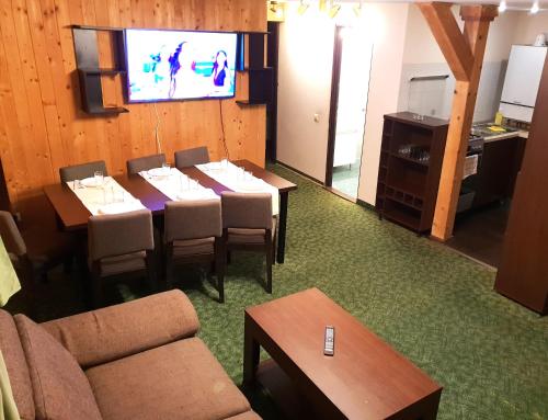 a dining room with tables and a flat screen tv at Traveland Boutique Resort Poiana Brasov in Poiana Brasov