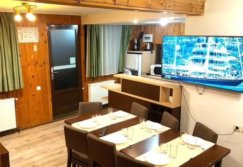 a dining room with tables and a large flat screen tv at Traveland Boutique Resort Poiana Brasov in Poiana Brasov