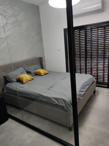 un letto con due cuscini gialli in una stanza di סוויט דרים בגושן a Qiryat Motzkin