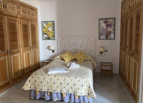 1 dormitorio con 1 cama y 2 armarios de madera en Apartamento Rural Prado del Rey en Prado del Rey