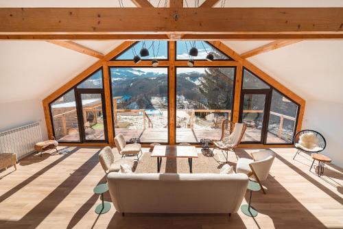 a room with a table and chairs and windows at StockEstate Moieciu in Moieciu de Jos