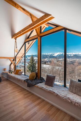 a room with a large window with mountains in the background at StockEstate Moieciu in Moieciu de Jos