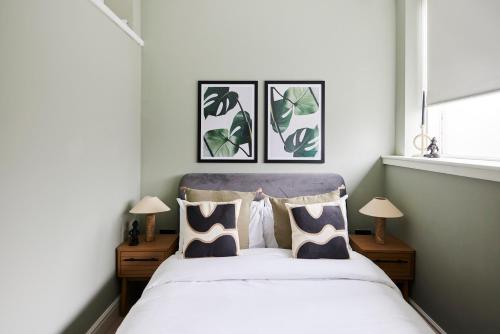 ロンドンにあるThe Waltham Forest Escape - Adorable 2BDR Flatのベッドルーム1室(壁に3枚の写真が飾られたベッド1台付)