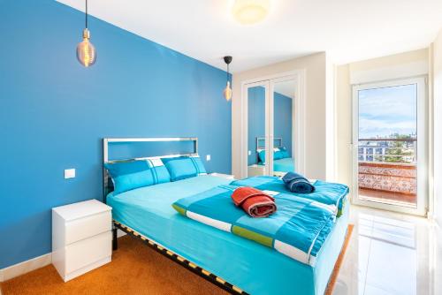 a blue bedroom with a bed and a window at La Nogalera - Sea view apartment in the heart of Torremolinos in Torremolinos