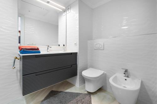 a bathroom with a sink and a toilet and a mirror at La Nogalera - Sea view apartment in the heart of Torremolinos in Torremolinos