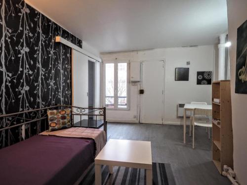 une chambre avec un lit et une table dedans dans l'établissement Appartement JARDINS DU LOUVRE, à Paris