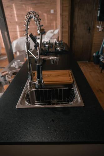 a kitchen counter with a sink with a dish drying rack at Cabanas nos Canyons in Praia Grande