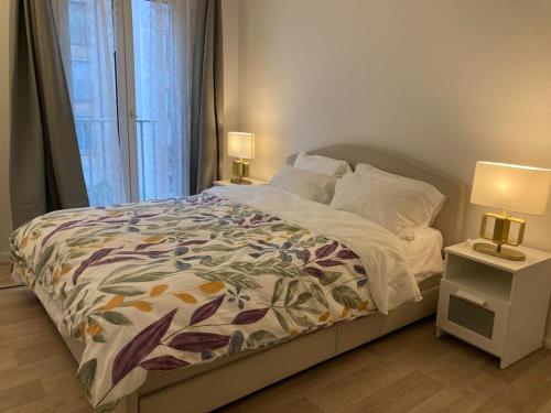 een slaapkamer met een bed en twee lampen op tafels bij Appartement entier avec parking gratuit proche de Paris et Aéroport d'Orly in Thiais