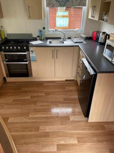 a kitchen with a sink and a stove top oven at Van number 123 Beautiful Caravan sleeps 4 to 6 in Aberystwyth