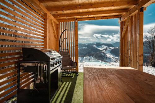 a porch with a stove and a view of a mountain at StockEstate Moieciu in Moieciu de Jos