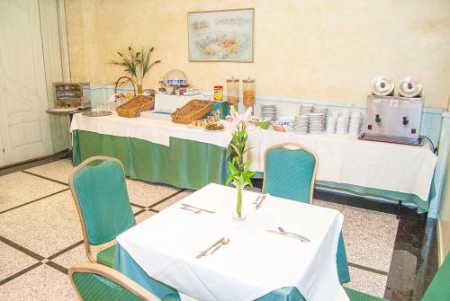 a table with white tables and chairs in a room at Ana María in Granada