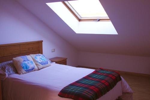 a bedroom with a large bed with a skylight at Apartamento Vista al Ara in Aínsa