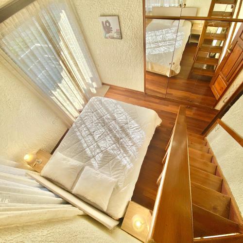 a room with a staircase with a bed and a mirror at Villa Naya by the Beach in Anavissos