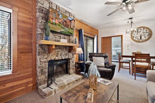 a living room with a stone fireplace and a couch at Beautiful Seven Springs- 2 Bed, 2 Bath Condo in Champion