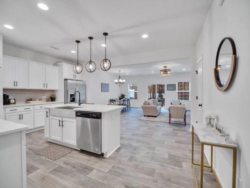 a kitchen with white cabinets and a living room at Gorgeous New Townhome/Charlotte! in Charlotte