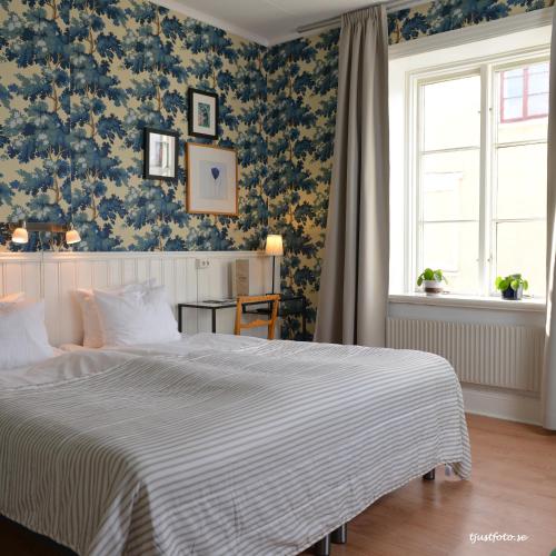 a bedroom with a large bed with blue and white sheets at Hotell Park in Västervik