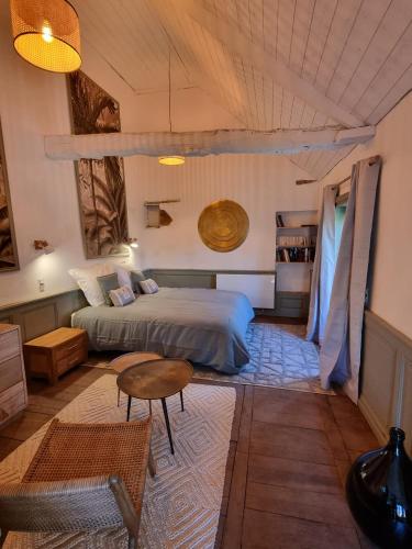 une chambre avec un lit et une table dans l'établissement La Seigneurie des Ondes, à Saint-Benoît-des-Ondes