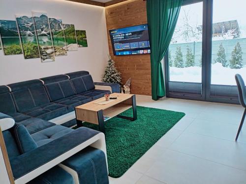 ein Wohnzimmer mit einem Sofa und einem Tisch in der Unterkunft Twoje Miejsce in Czarna Góra