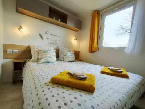 ein Schlafzimmer mit einem Bett mit zwei Handtüchern darauf in der Unterkunft Vos MEILLEURS Vacances en Mobil Home in Gastes