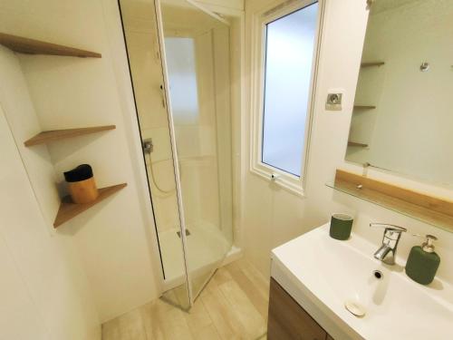 ein Badezimmer mit einem weißen Waschbecken und einer Dusche in der Unterkunft Vos MEILLEURS Vacances en Mobil Home in Gastes