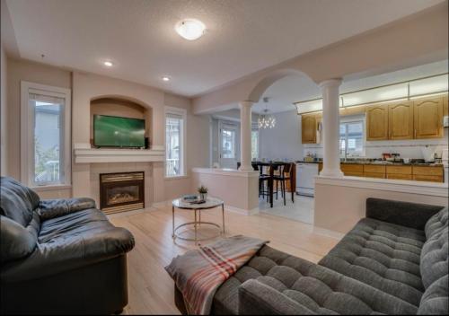 a living room with a couch and a fireplace at Big family home w/ Deck, Ping Pong, BBQ & Garage in Edmonton