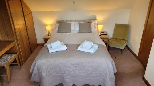 a bedroom with a large bed with two pillows on it at Criffel Cottage in Dumfries