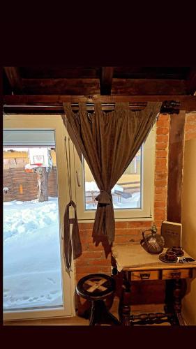 a room with a window with a desk and a table at Njih tri Jelova gora in Užice