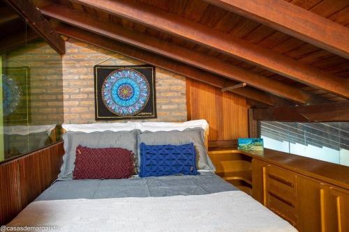 Casa aconchegante ampla e charmosa في مورو دي ساو باولو: غرفة نوم بسرير ومخدات زرقاء وحمراء