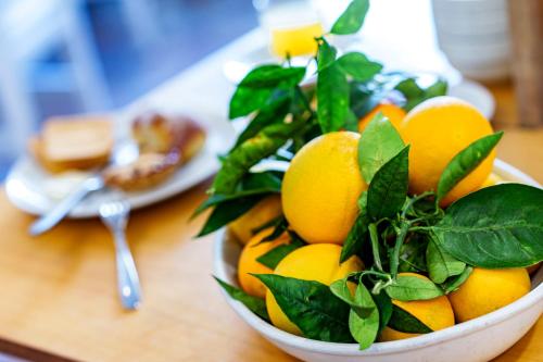 a bowl of lemons on a table with a plate of food at Hotel Tourist in Sorrento