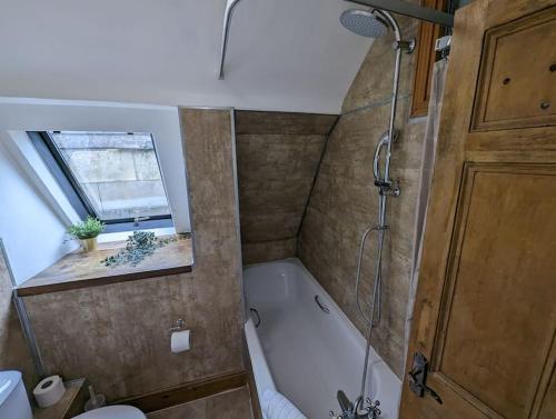 uma casa de banho com um chuveiro e uma banheira em River Street Rest em Bath