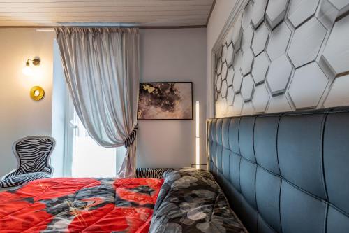 a bedroom with a bed and a zebra chair at LORI'S INN 2 in Mondovì