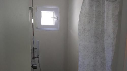 a bathroom with a shower curtain and a window at KAS RESIDENCE renovated 2022 in Spetses