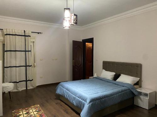 1 dormitorio con 1 cama con edredón azul en Heliopolis Residence Shrouk city Cairo, en Madīnat ash Shurūq