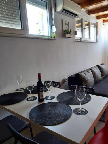 uma mesa com copos e uma garrafa de vinho em KaLo, novouređen stan + besplatan parking em Murvica