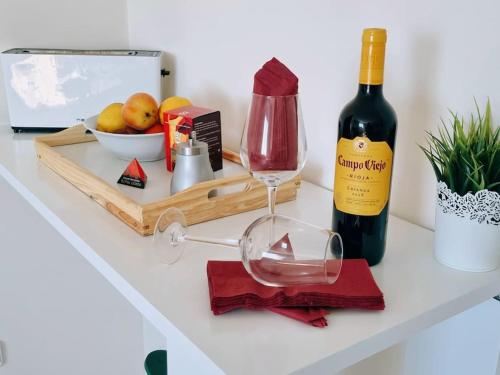 uma mesa com uma garrafa de vinho e um copo de vinho em Precioso ático con terraza em Benicarló