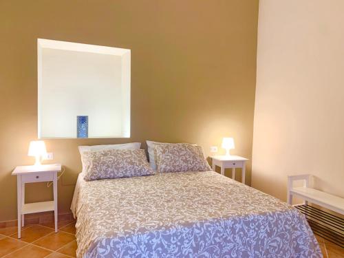 a bedroom with a bed with two nightstands and two lamps at Artis Mare in Pozzuoli