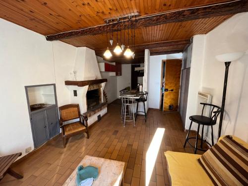 een woonkamer met een houten plafond en een open haard bij Louis Maissa in Saint-Martin-Vésubie