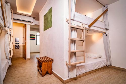 カンクンにあるNomads Party Hostelの二段ベッド2台と廊下が備わる客室です。