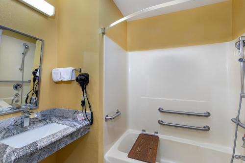 a bathroom with a sink and a mirror at Super 8 by Wyndham Eddyville/Kuttawa in Eddyville