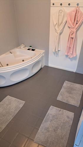 a bathroom with a tub and two rugs at Évika boutique hotel in Eskilsby