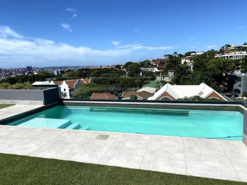 a large blue swimming pool on top of a house at Upmarket Modern 1 Bedroom Apartment in Durban