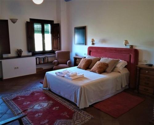 - une chambre avec un grand lit et une tête de lit rouge dans l'établissement Villa Carmen Magnificent Country House in Serranía, à Ronda