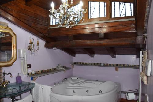 ein Badezimmer mit einer Badewanne und einem Kronleuchter in der Unterkunft B&B Vittoria Colonna in Marino