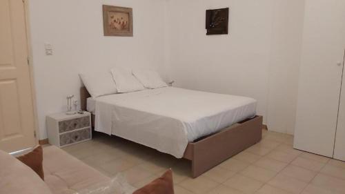 1 dormitorio con 1 cama grande con sábanas blancas en KAS RESIDENCE renovated 2022 en Spétses