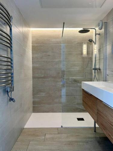 une salle de bain avec douche et lavabo dans l'établissement Le Lily - T2 neuf vue mer, à Èze