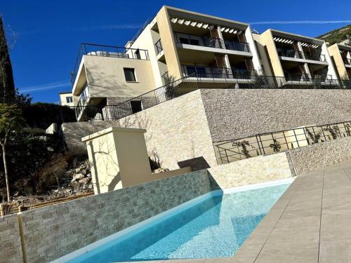 uma casa com piscina em frente a uma casa em Le Lily - T2 neuf vue mer em Èze