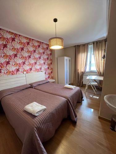 1 dormitorio con 1 cama grande y lavamanos en Hosteria Tajahierro, en Reinosa