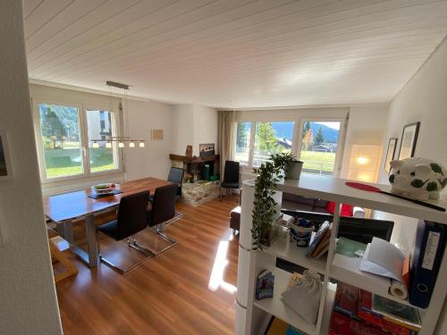 un soggiorno con scrivania, tavolo e sedie di Apartment Arvenbüel-Flüügespitz ad Amden