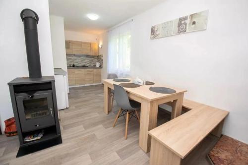 a living room with a table and a wood stove at Chaloupka Všemily in Jetřichovice